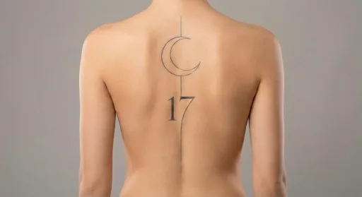 fine line moon tattoo on the spine