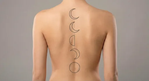 minimal moon tattoo on the spine