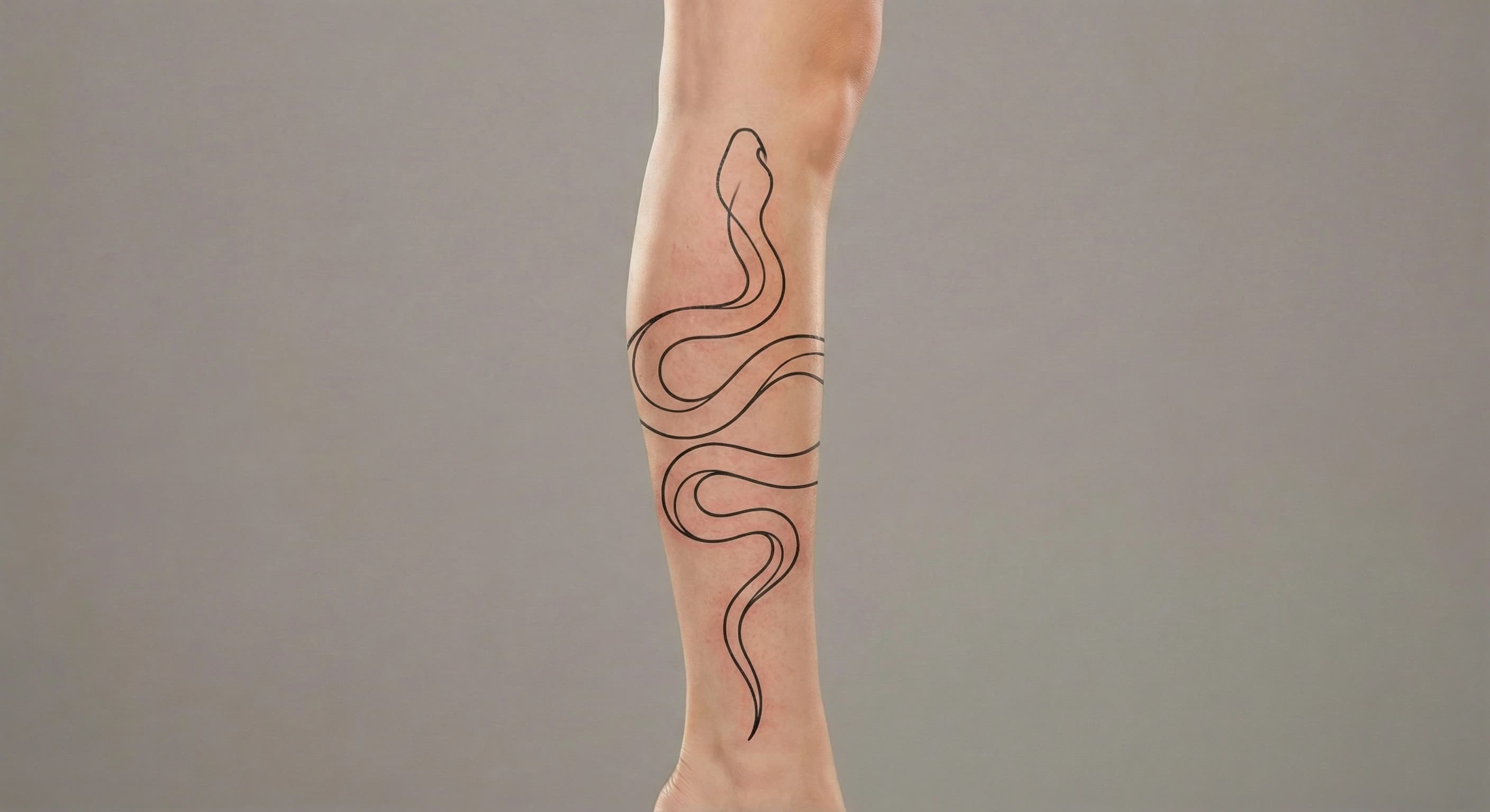 fine line snake tattoo on the leg